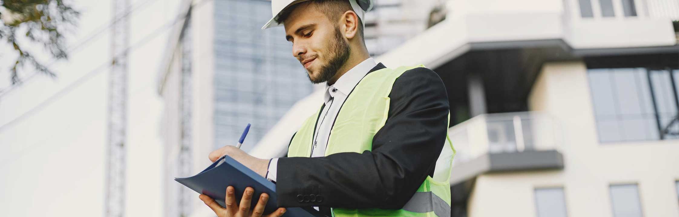 safety manager wearing hard hat and using clipboard